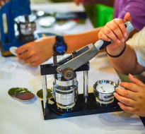 person making button badges with a button maker