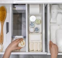 Eco-FriendlyHomeOrganizing.jpg Someone's hands organizing a bathroom drawer