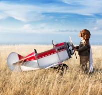 Exploring_Stratford_Logo.jpg a kid looking at a small airplane in a field