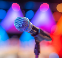 mic.png a microphone against a colourful background of stage lights