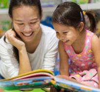 ReadingBuddies_Logo.jpg a child and and adult looking happy reading together