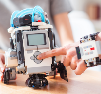 finger pressing a button on Lego Mindstorm robot