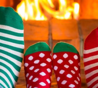 Family in Christmas socks near fireplace