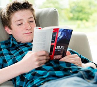 teen boy reading a book