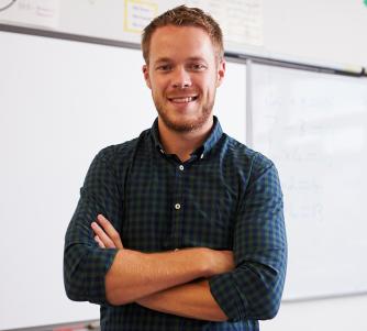 Male teacher standing with arms crossed