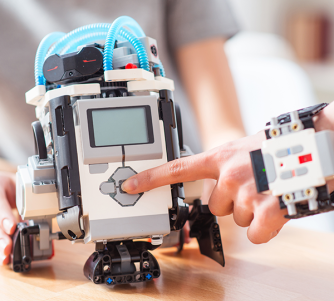 finger pressing a button on Lego Mindstorm robot