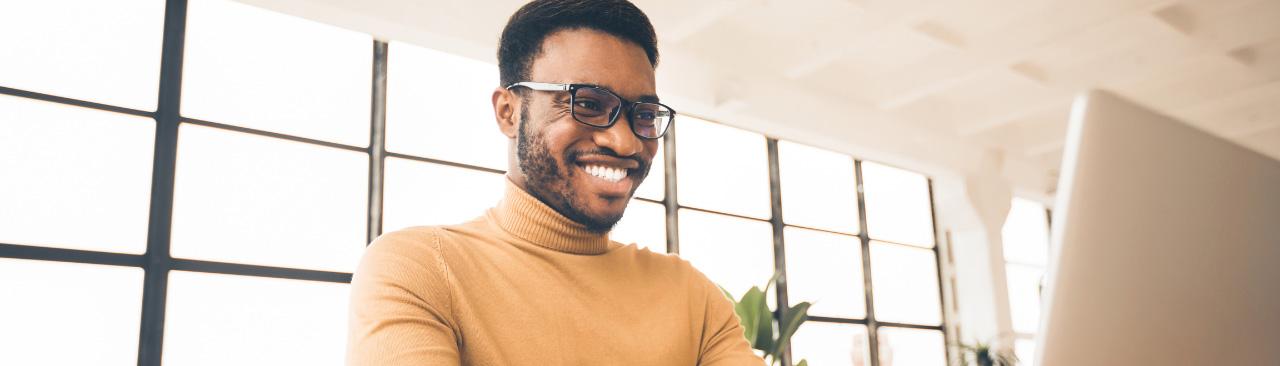 Someone smiling while using their laptop