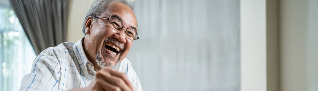 BrainGains_hero.png A senior laughing while he makes a chess move.