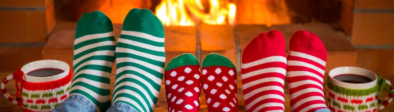 Family in Christmas socks near fireplace