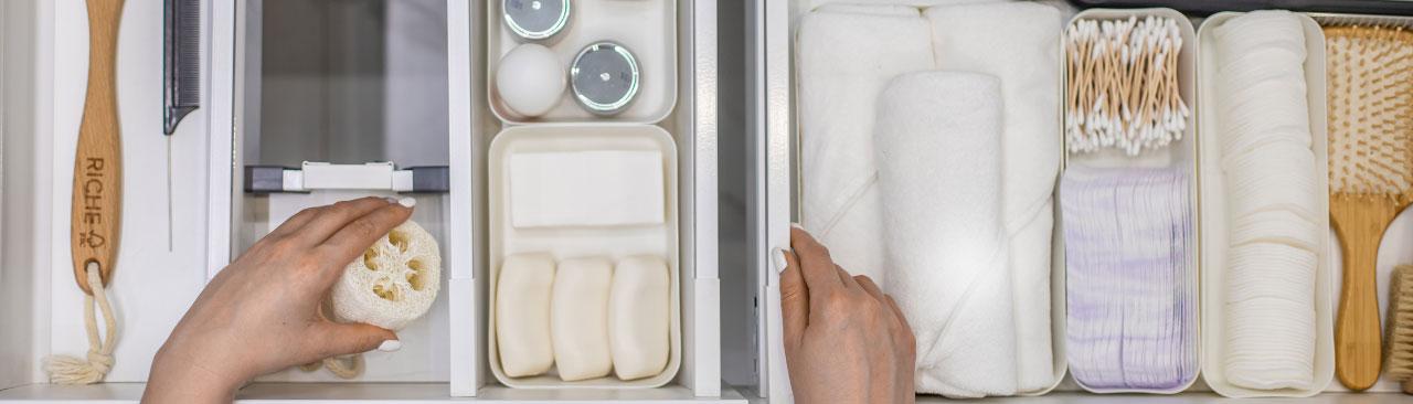 EcoFriendlyHomeOrganizing_hero.jpg A person's hands organizing a bathroom drawer