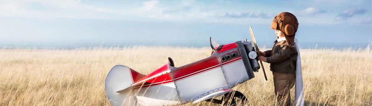 Exploring-Stratford_hero.jpg A kid looking at a small plane in a field