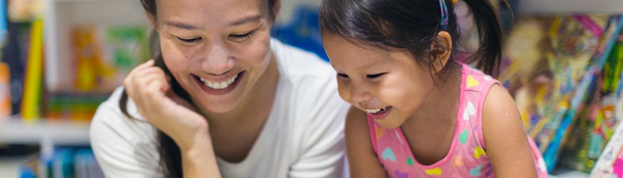 ReadingBuddies_hero.jpg a child and and adult looking happy reading together