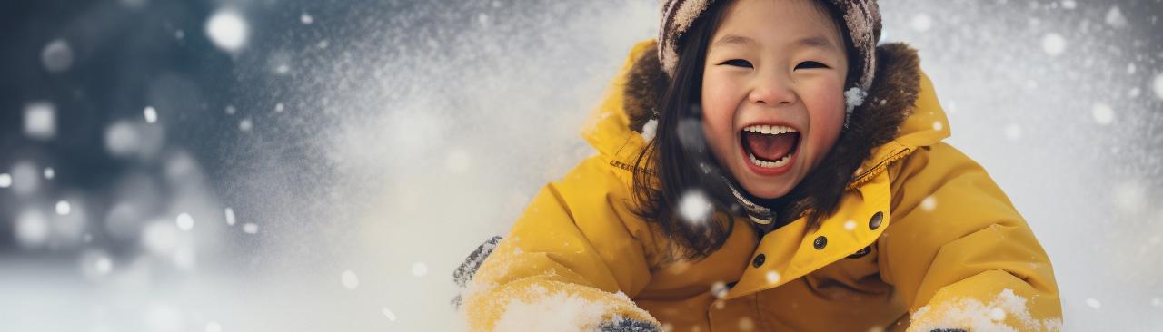 winter-break-bash.jpg A kid sliding on a toboggan in the snow looking delighted